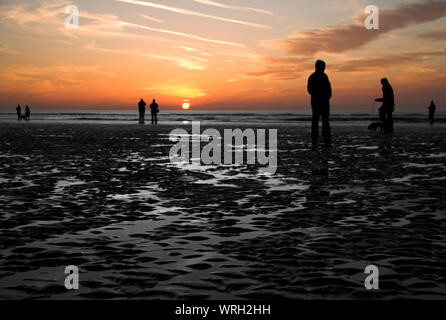 La gente sulla spiaggia al tramonto, Cleveleys, Blackpool, Inghilterra, Regno Unito Foto Stock