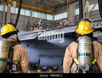 I vigili del fuoco dalla 103 Ingegnere Civile Squadron egress un manutentore simulato da un C-130H Hercules serbatoio del carburante durante uno spazio confinato esercitazione di soccorso presso la cella a combustibile e il controllo della corrosione facility, Bradley Air National Guard Base, East Granby, Conn. Sett. 8, 2019. L'esercizio annuale è uno sforzo congiunto con il fuoco e con i servizi di emergenza, la 103 Squadrone di manutenzione i sistemi di alimentazione carburante officina di manutenzione e 103 Airlift Wing ufficio di sicurezza per eseguire un piano di risposta in caso di un manutentore è ferito dentro lo spazio confinato di un C-130 il serbatoio del combustibile. (U.S. Air National Guard foto di Chief Master Foto Stock