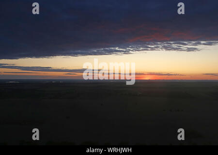 Colorato cielo drammatico con il cloud al tramonto su campi vicino a Kiev, Ucraina. Vista dal piano. Al tramonto i raggi del sole Foto Stock