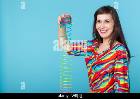 UFA, Russia - 26 Maggio 2017 : giovane donna giocando con una slinky su sfondo blu Foto Stock