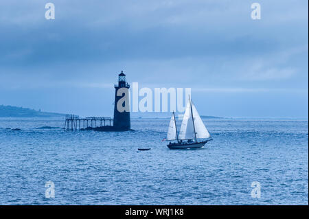 Grandi barche a vela passando dalla Ram battuta Island Lighthouse a Portland, Maine, Stati Uniti d'America Foto Stock