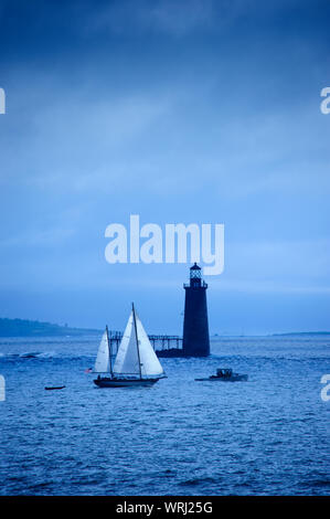 Grandi barche a vela passando dalla Ram battuta Island Lighthouse a Portland, Maine, Stati Uniti d'America Foto Stock