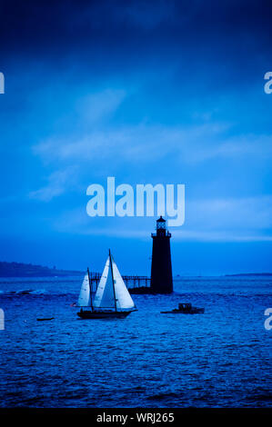 Grandi barche a vela passando dalla Ram battuta Island Lighthouse a Portland, Maine, Stati Uniti d'America Foto Stock