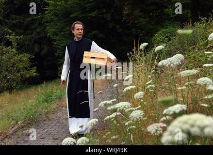 Il 15 luglio 2019, della Renania settentrionale-Vestfalia, Bochum: Padre Justinus passeggiate attraverso il giardino di erbe aromatiche del monastero cistercense nel distretto di Stiepel. Nella sua produzione egli produce una elevata percentuale di gin e lo chiama "onatic dry gin'. Le erbe aromatiche di cui ha bisogno sono piantate e coltivate nel giardino del monastero. Egli riceve il ginepro provenienti dalla Toscana e il grano da cui l'alcool è ottenuto egli riceve dalla madre Abbazia di Heiligenkreuz nella Foresta Viennese. Nel monastero stesso egli non è permesso di bruciare qualsiasi gin perché non hanno alcun diritto di distillazione. Per questo egli unità ad un produttore nearb Foto Stock