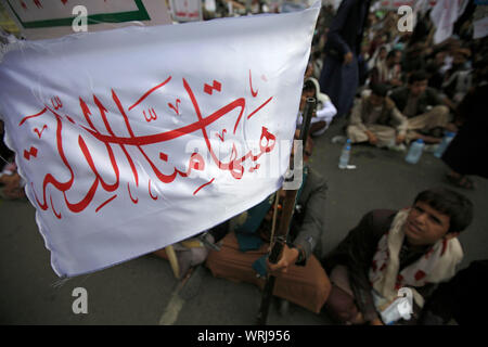 Sanaa, Yemen. Decimo Sep, 2019. I sostenitori dello Yemen's sciita ribelli Houthi, wave bandiere con un Arabo scritta 'disgrace è lontana da noi', che prendono parte a una processione religiosa per contrassegnare il giorno di Ashura, che cade il decimo giorno di Muharram, il primo mese del calendario islamico. Ashura segna il giorno in cui Husayn ibn Ali, il nipote del profeta islamico Maometto, è stato ucciso nella battaglia di Karbala che fu combattuta il 10 ottobre 680. Credito: Hani Al-Ansi/dpa/Alamy Live News Foto Stock