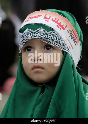 Sanaa, Yemen. Decimo Sep, 2019. Una ragazza yemenita che indossa una bandana con un Arabo scritta "sul vostro servizio Hussein', assiste alla processione religiosa detenute dai ribelli Houthi per contrassegnare il giorno di Ashura, che cade il decimo giorno di Muharram, il primo mese del calendario islamico. Ashura segna il giorno in cui Husayn ibn Ali, il nipote del profeta islamico Maometto, è stato ucciso nella battaglia di Karbala che fu combattuta il 10 ottobre 680. Credito: Hani Al-Ansi/dpa/Alamy Live News Foto Stock