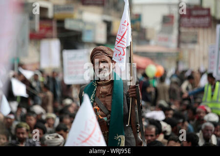 Sanaa, Yemen. Decimo Sep, 2019. Un yemenita uomo sciita, mantiene la sua arma e una bandiera con un Arabo iscrizione leggere 'disgrace è lontana da noi", come egli prende parte a una processione religiosa detenute dai ribelli Houthi per contrassegnare il giorno di Ashura, che cade il decimo giorno di Muharram, il primo mese del calendario islamico. Ashura segna il giorno in cui Husayn ibn Ali, il nipote del profeta islamico Maometto, è stato ucciso nella battaglia di Karbala che fu combattuta il 10 ottobre 680. Credito: Hani Al-Ansi/dpa/Alamy Live News Foto Stock