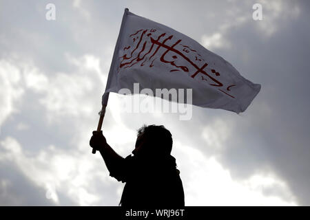 Sanaa, Yemen. Decimo Sep, 2019. Un yemenita uomo sciita detiene una bandiera con un Arabo scritta "sul vostro servizio Hussein", prende parte a una processione religiosa detenute dai ribelli Houthi per contrassegnare il giorno di Ashura, che cade il decimo giorno di Muharram, il primo mese del calendario islamico. Ashura segna il giorno in cui Husayn ibn Ali, il nipote del profeta islamico Maometto, è stato ucciso nella battaglia di Karbala che fu combattuta il 10 ottobre 680. Credito: Hani Al-Ansi/dpa/Alamy Live News Foto Stock