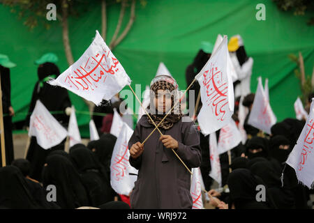 Sanaa, Yemen. Decimo Sep, 2019. Una ragazza yemenita contiene indicatori con un Arabo scritta 'disgrace è lontana da noi", come lei prende parte a una processione religiosa detenute dai ribelli Houthi per contrassegnare il giorno di Ashura, che cade il decimo giorno di Muharram, il primo mese del calendario islamico. Ashura segna il giorno in cui Husayn ibn Ali, il nipote del profeta islamico Maometto, è stato ucciso nella battaglia di Karbala che fu combattuta il 10 ottobre 680. Credito: Hani Al-Ansi/dpa/Alamy Live News Foto Stock