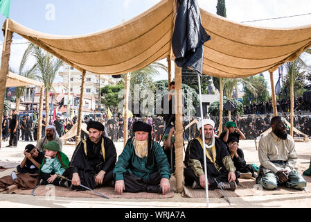 Persone in Jibchit, Nabatiyeh comune, Libano, in lutto per la morte di imam Hussein, nipote del Profeta Maometto, attraverso una rievocazione storica della sua morte durante la battaglia di Karbala in 680annuncio. Un cast di 100 ha preso parte, completa con i cavalli e un cammello. Il Libano, 10 Settembre 2019 Foto Stock