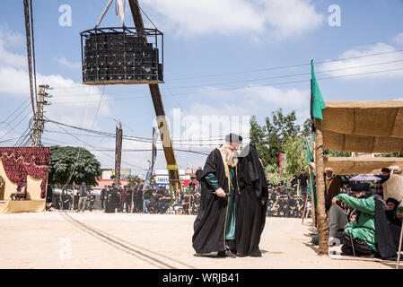 Persone in Jibchit, Nabatiyeh comune, Libano, in lutto per la morte di imam Hussein, nipote del Profeta Maometto, attraverso una rievocazione storica della sua morte durante la battaglia di Karbala in 680annuncio. Un cast di 100 ha preso parte, completa con i cavalli e un cammello. Il Libano, 10 Settembre 2019 Foto Stock