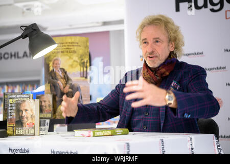 Monaco di Baviera, Germania. Decimo Sep, 2019. Thomas Gottschalk, presentatore, accoglie favorevolmente il pubblico durante una lettura dalla sua nuova autobiografia 'Herbstbunt'. Credito: Matthias esitano di fronte/dpa/Alamy Live News Foto Stock