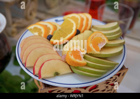 Apple rosso, arancio, pere, kiwi, uva. frutta a fette sono all'interno della piastra. Foto Stock