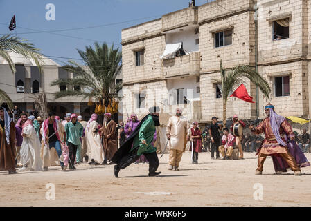 Persone in Jibchit, Nabatiyeh comune, Libano, in lutto per la morte di imam Hussein, nipote del Profeta Maometto, attraverso una rievocazione storica della sua morte durante la battaglia di Karbala in 680annuncio. Un cast di 100 ha preso parte, completa con i cavalli e un cammello. Il Libano, 10 Settembre 2019 Foto Stock