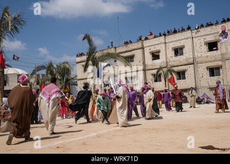 Persone in Jibchit, Nabatiyeh comune, Libano, in lutto per la morte di imam Hussein, nipote del Profeta Maometto, attraverso una rievocazione storica della sua morte durante la battaglia di Karbala in 680annuncio. Un cast di 100 ha preso parte, completa con i cavalli e un cammello. Il Libano, 10 Settembre 2019 Foto Stock