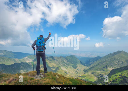 Successo attivo uomo escursionista sulla cima della montagna godendo la vista. Viaggio sport concetto di stile di vita Foto Stock