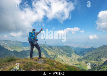 Successo attivo uomo escursionista sulla cima della montagna godendo la vista. Viaggio sport concetto di stile di vita Foto Stock