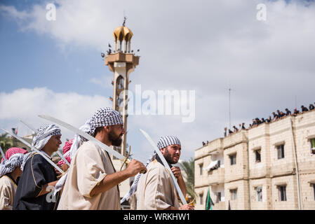Persone in Jibchit, Nabatiyeh comune, Libano, in lutto per la morte di imam Hussein, nipote del Profeta Maometto, attraverso una rievocazione storica della sua morte durante la battaglia di Karbala in 680annuncio. Un cast di 100 ha preso parte, completa con i cavalli e un cammello. Il Libano, 10 Settembre 2019 Foto Stock