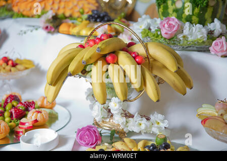 Esso giaceva su piastra di acciaio inossidabile in outdoor .all'interno di banane non cotte e granchio rosso apple di vetro . Pettine di banane che problemi di attualità asia thailandia frutto in giallo Foto Stock