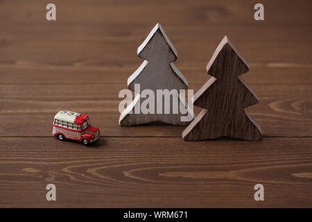 Alberi di legno con un auto in miniatura closeup isolato sul tavolo Foto Stock