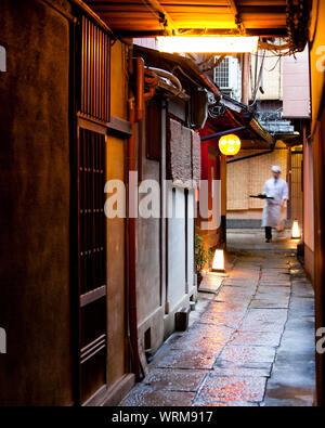 Lo chef che trasportano derrate alimentari ad un ristorante, tra i vicoli del quartiere di Gion, Kyoto Foto Stock