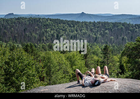 Coppia giovane sul quarto pilastro rock del Stolby Riserva Naturale, Siberia, Russia Foto Stock