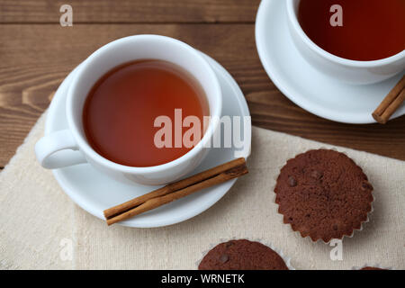 Tortini di cioccolato isolato su un tavolo di legno con tazza da tè Foto Stock