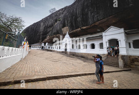 DAMBULLA / SRI LANKA - Agosto 07, 2019: la vaga fanciulla sta prendendo foto presso la più grande grotta di Dambulla, Sri Lanka. La più grande grotta per TH Foto Stock