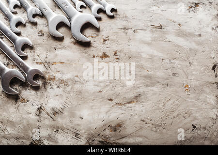 Chiavi di manovra. Molte chiavi. Background Industriale. Set di utensili chiave attrezzatura. Set di chiavi in diverse dimensioni su sfondo grigio. Vista superiore con Foto Stock