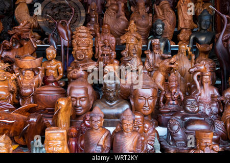 Una grande raccolta di legno intagliato Buddha e altre figure per la vendita presso il principale mercato centrale in Phnom Penh Cambogia. Foto Stock