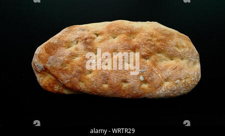 Filone di pane Ciabatta su tavoli in legno nero Foto Stock