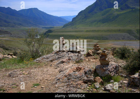 Una pietra sacra cairn sulla cima di una montagna che si affaccia sulla valle. Altai, Siberia, Russia. Foto Stock