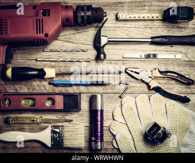Set di strumenti su un asse di legno in background vintage Foto Stock