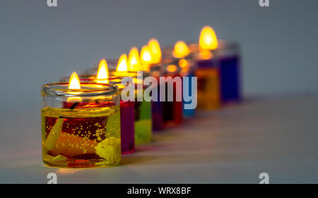 Piccole candele colorate su sfondo scuro Foto Stock