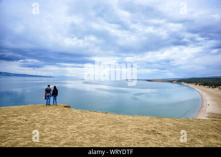 Regione di Irkutsk, Russia - 16 settembre 2017: Albero e silhouette di coppia nell'isola di Olkhon con il cielo e le nuvole bellissimi, popolare destinazione di viaggio Foto Stock