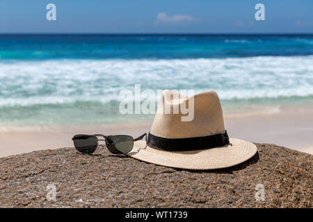 Cappello e occhiali da sole sulla spiaggia Foto Stock