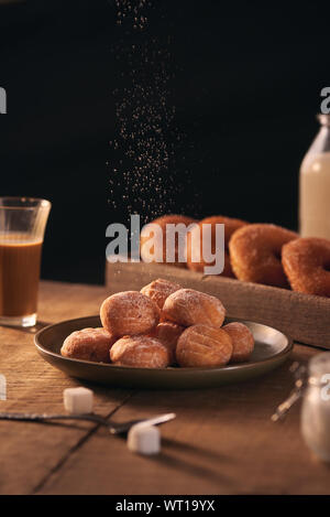 Palline di pane appena sfornato in casa cottage cheese ciambelle in una piastra su sfondo grigio. Foto Stock