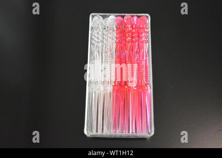 Bastoncini in plastica trasparente e rossa per piccoli sandwich e canapè in imballaggi in plastica. Foto Stock