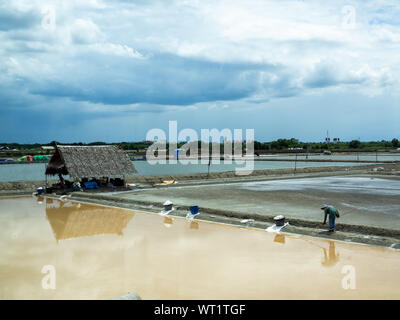 Samut Sakhon, Tailandia - 16 giugno 2019: Sale agricoltore shoveled cristallo di sale nel sale giardino, sale agricoltura in Samut Sakhon, Thailandia. Foto Stock