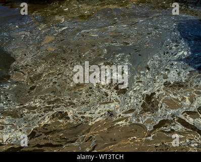 Fuoriuscita di olio galleggiante sulla superficie del mare Foto Stock