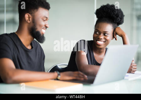Immagine di due giovani imprenditori che interagiscono su riunione in ufficio Foto Stock