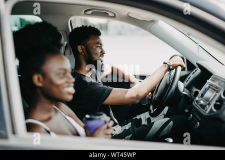 Tempo libero, viaggio, viaggiare, famiglia e concetto di persone - happy l uomo e la donna alla guida in auto con il caffè Foto Stock