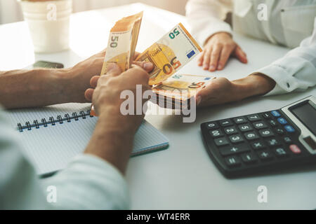 Economia sommersa, la corruzione e l'occupazione illegale concetto - pagamento in contanti tra due persone Foto Stock