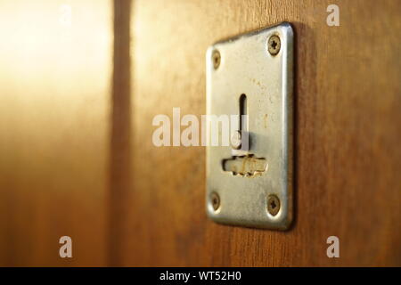Brown porta in legno con chrome keyhole e raggi di sole Foto Stock