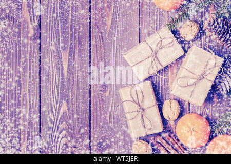 Composizione di Natale con i tangerini, confezioni regalo, coni su legno scuro dello sfondo. Vista da sopra con copia spazio. Foto Stock