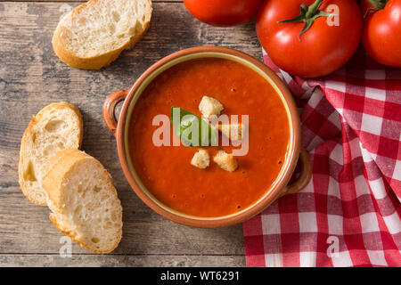 Zuppa di pomodoro nel recipiente marrone sul tavolo di legno. Vista superiore Foto Stock
