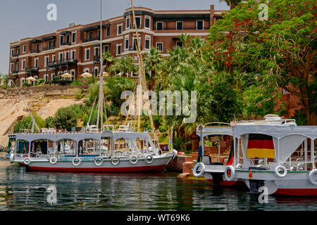 Piccoli traghetti passeggeri barche ancorata di fronte allo storico Old Cataract Hotel in Aswan Foto Stock