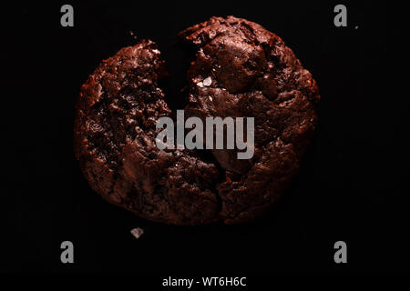 Top visualizza immagine di rotture di soft cookie al cioccolato con scaglie di sale su sfondo scuro Foto Stock