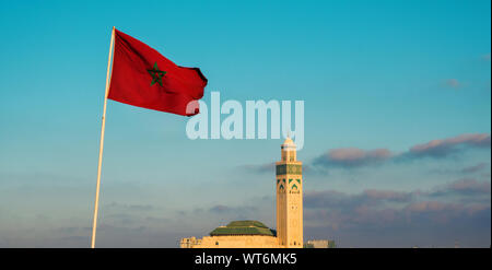 Vista la famosa moschea di Hassan II e una sventola bandiera marocchino contro sky - Casablanca - Marocco Foto Stock