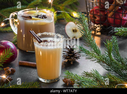 Sidro di mela cocktail con il cardamomo e anice stellato sulla tavola nera con abete rami. Close up. Foto Stock